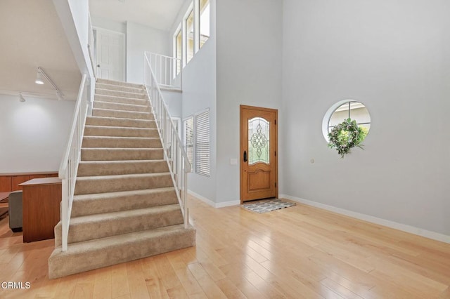 11998 Bubbling Brook St, Moorpark, CA 93021 - foyer entrance with stairs, hardwood / wood-style floors, baseboards, track lighting, and a towering ceiling
