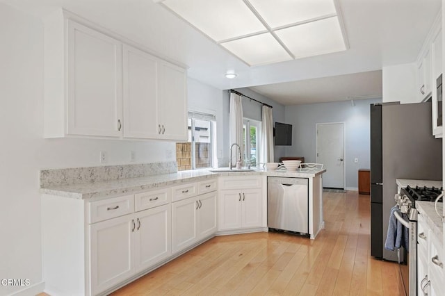 11998 Bubbling Brook St, Moorpark, CA 93021 - kitchen featuring stainless steel appliances, a peninsula, white cabinets, and a sink