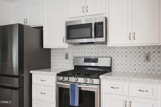 11998 Bubbling Brook St, Moorpark, CA 93021 - kitchen with appliances with stainless steel finishes, tasteful backsplash, white cabinetry, and light stone countertops