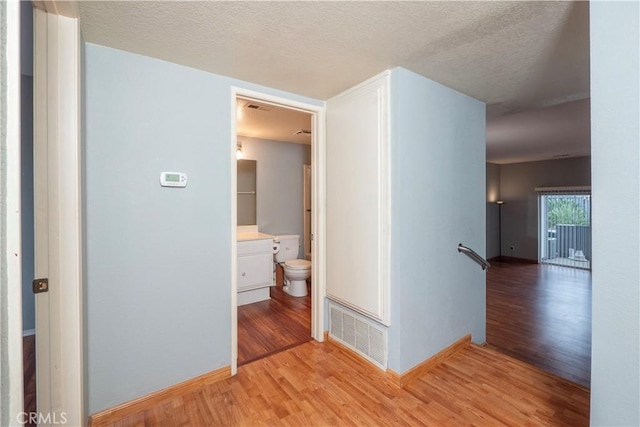 776 E San Bernardino Rd Unit 3, Covina, CA 91723 - hallway featuring light wood-type flooring, baseboards, a textured ceiling, and an upstairs landing