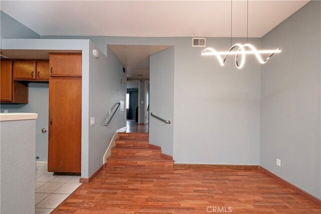 776 E San Bernardino Rd Unit 3, Covina, CA 91723 - kitchen featuring light wood-style flooring, a chandelier, brown cabinets, baseboards, and hanging light fixtures