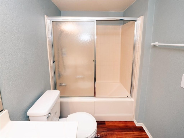 776 E San Bernardino Rd Unit 3, Covina, CA 91723 - full bathroom with a textured wall, wood finished floors, combined bath / shower with glass door, toilet, and baseboards