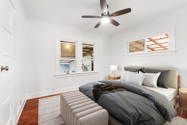 bedroom with dark wood-type flooring, crown molding, a ceiling fan, and baseboards