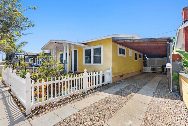 view of front of home with crawl space, a fenced front yard, and an attached carport