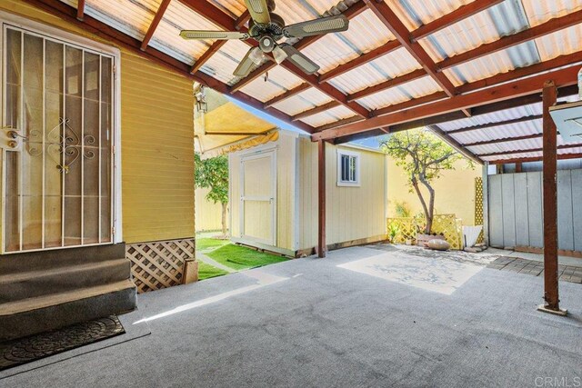 view of patio featuring a ceiling fan, an outbuilding, a storage shed, and entry steps