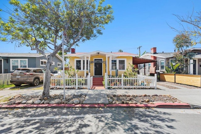 view of front of home with a fenced front yard and an attached carport