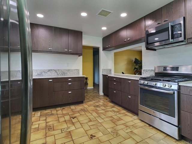 9884 Settle Rd, Santee, CA 92071 - kitchen with appliances with stainless steel finishes, light countertops, dark brown cabinetry, brick patterned flooring, and recessed lighting