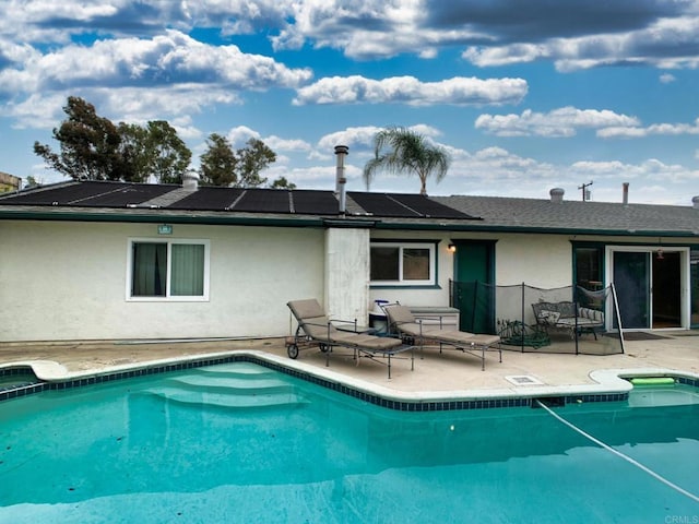 9884 Settle Rd, Santee, CA 92071 - rear view of house with stucco siding, roof mounted solar panels, a patio area, and a pool with connected hot tub