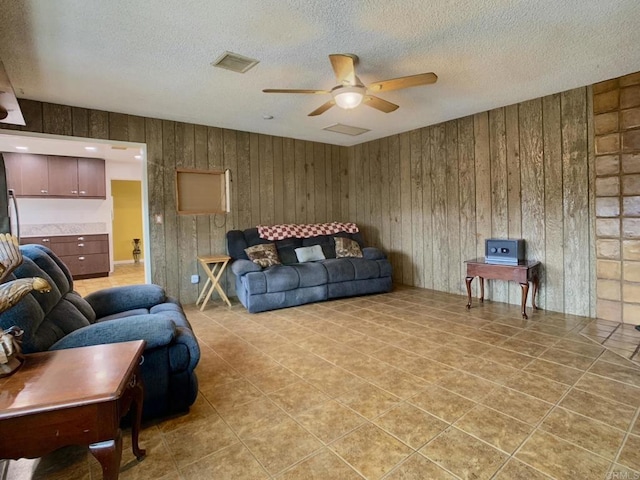 9884 Settle Rd, Santee, CA 92071 - living room with ceiling fan, a textured ceiling, wood walls, and light tile patterned floors