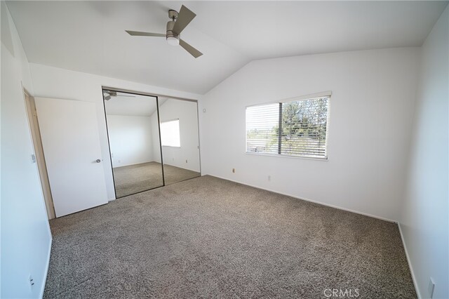 unfurnished bedroom featuring carpet floors, vaulted ceiling, a ceiling fan, and a closet