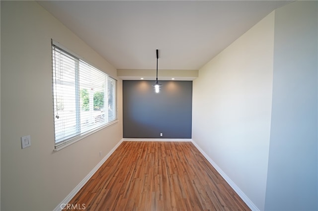unfurnished room featuring wood finished floors and baseboards