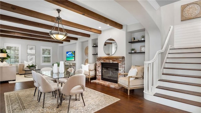 38 Upperbend, Irvine, CA 92618 - dining area with dark wood-style flooring, beamed ceiling, stairway, a brick fireplace, and built in shelves