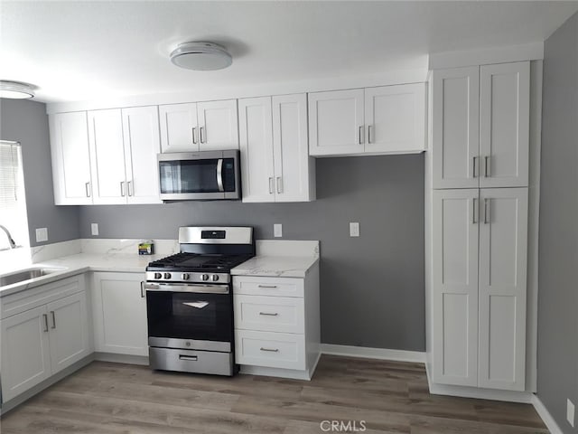 26702 Via Linares, Mission Viejo, CA 92691 - kitchen with stainless steel appliances, a sink, white cabinets, and light stone counters
