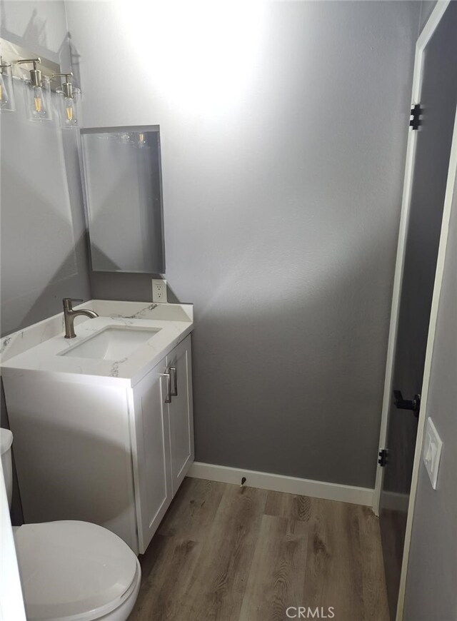 26702 Via Linares, Mission Viejo, CA 92691 - half bathroom with wood finished floors, vanity, toilet, and baseboards