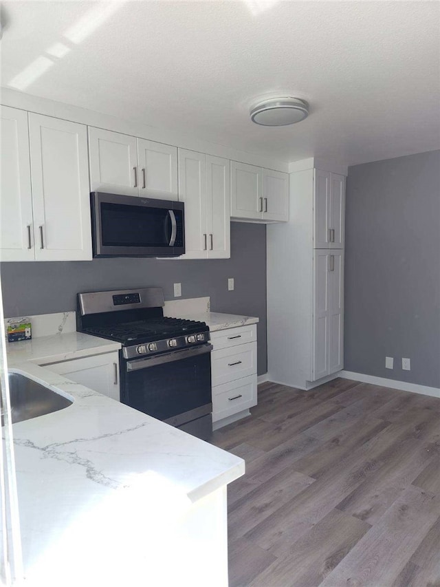 26702 Via Linares, Mission Viejo, CA 92691 - kitchen with appliances with stainless steel finishes, white cabinetry, light wood finished floors, and light stone counters