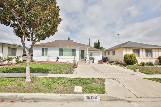 ranch-style home with a garage, stucco siding, and a front yard