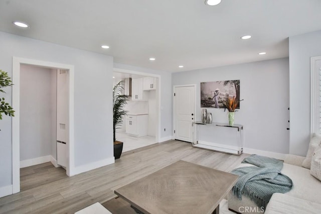 living room with light wood finished floors, recessed lighting, and baseboards