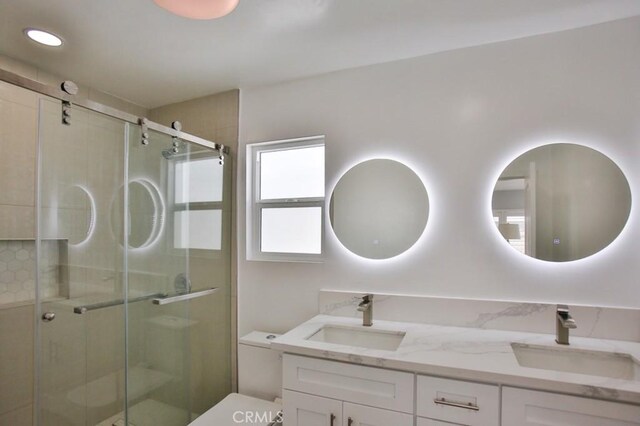 bathroom featuring a stall shower, double vanity, toilet, and recessed lighting