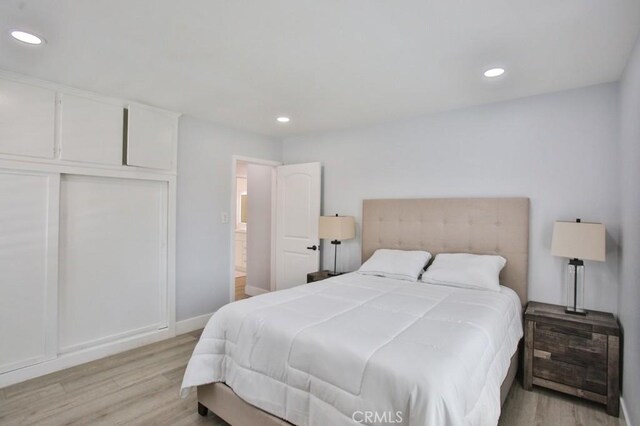 bedroom with light wood-type flooring, recessed lighting, and baseboards