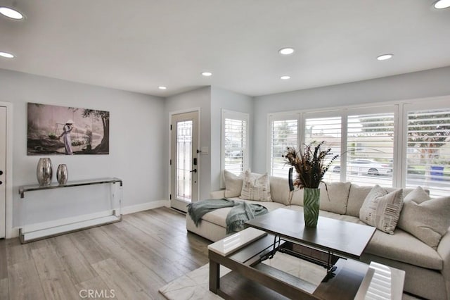 living area featuring light wood-type flooring, recessed lighting, and baseboards