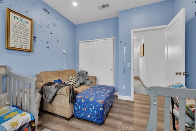 bedroom featuring wood finished floors, a closet, and baseboards