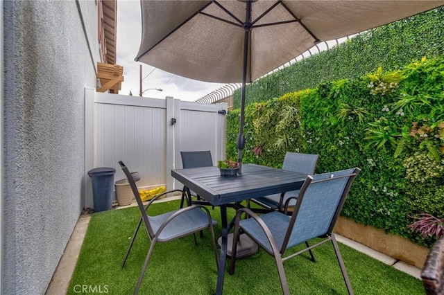 view of patio / terrace featuring outdoor dining space, fence, and a gate