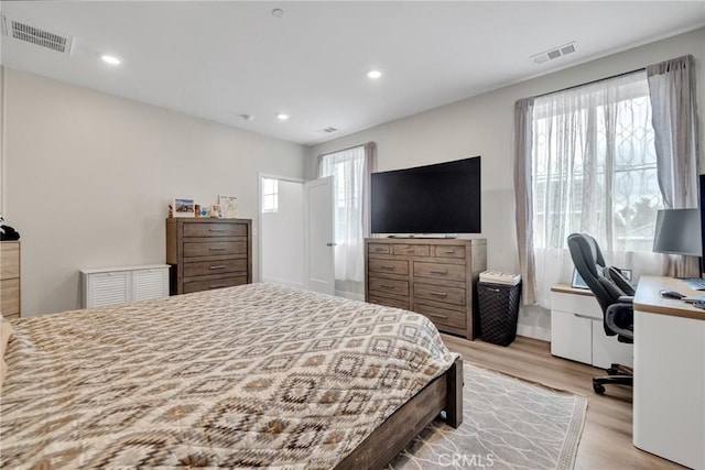 bedroom featuring light wood-style flooring, recessed lighting, and an office area