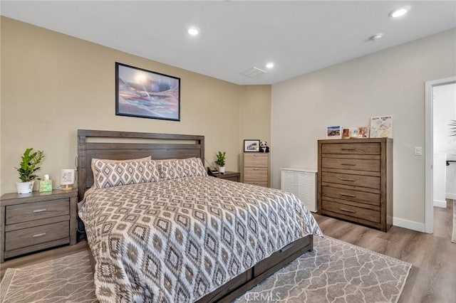 bedroom with wood finished floors, recessed lighting, and baseboards
