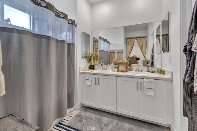 bathroom with double vanity, a shower with curtain, and baseboards