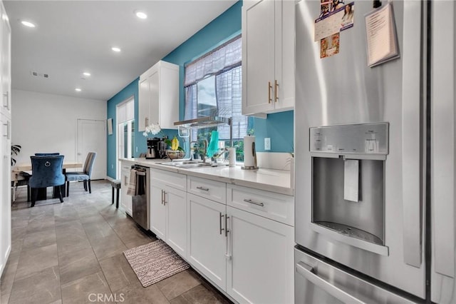 kitchen featuring appliances with stainless steel finishes, light countertops, recessed lighting, white cabinets, and a sink