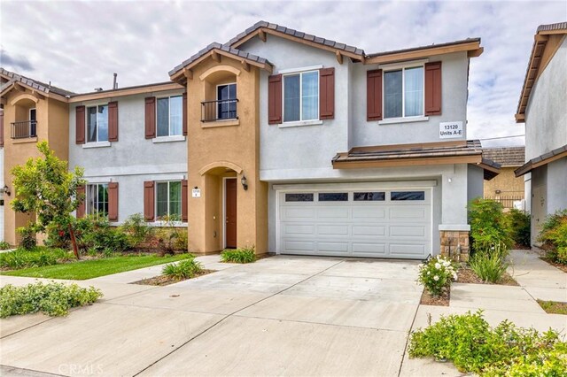 view of property featuring driveway, stucco siding, and an attached garage