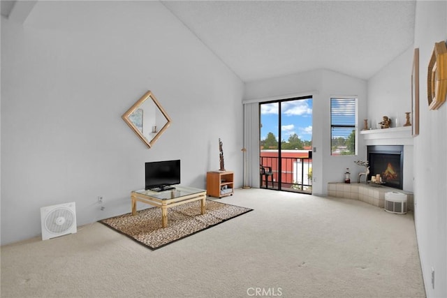 living area with carpet, a lit fireplace, and high vaulted ceiling