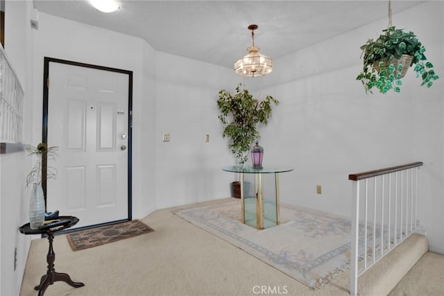 foyer with carpet floors, stairway, and a chandelier