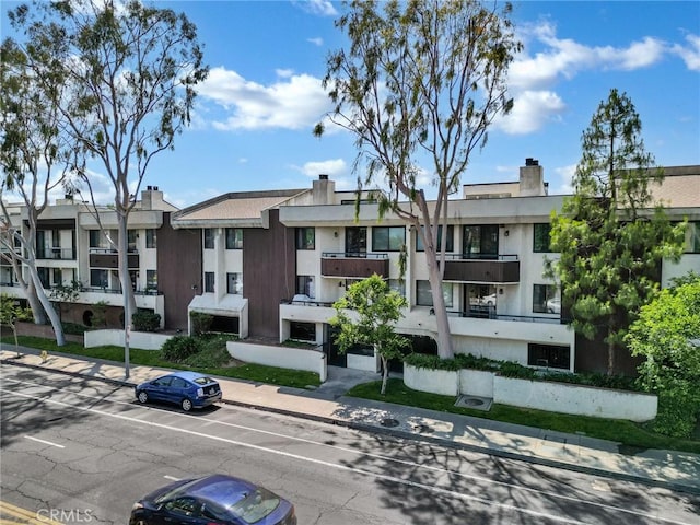 view of building exterior with a residential view and uncovered parking