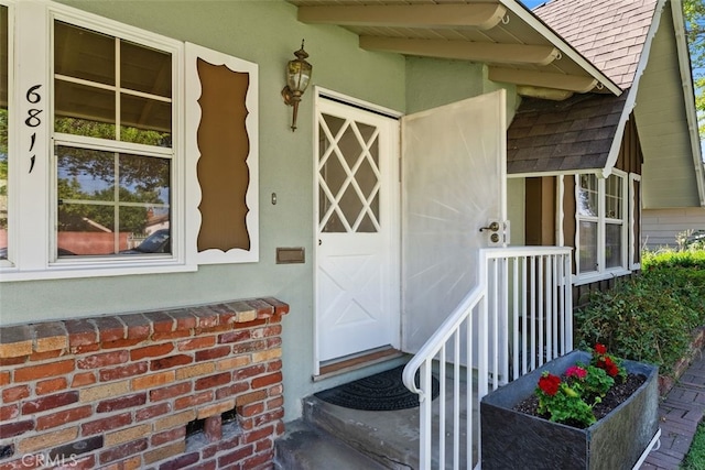 doorway to property with roof with shingles