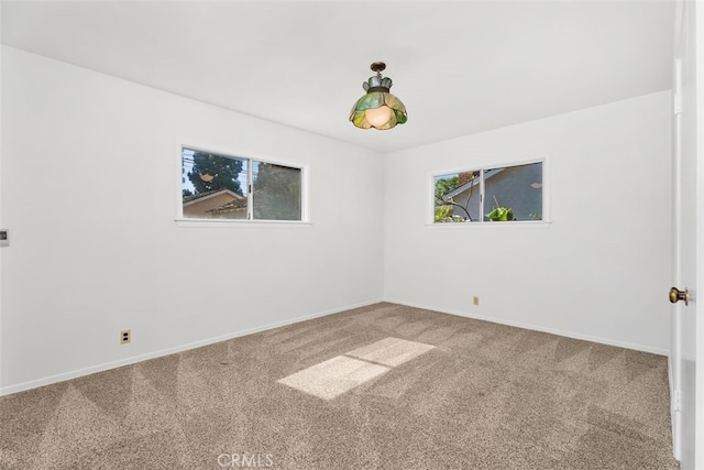 carpeted spare room with baseboards