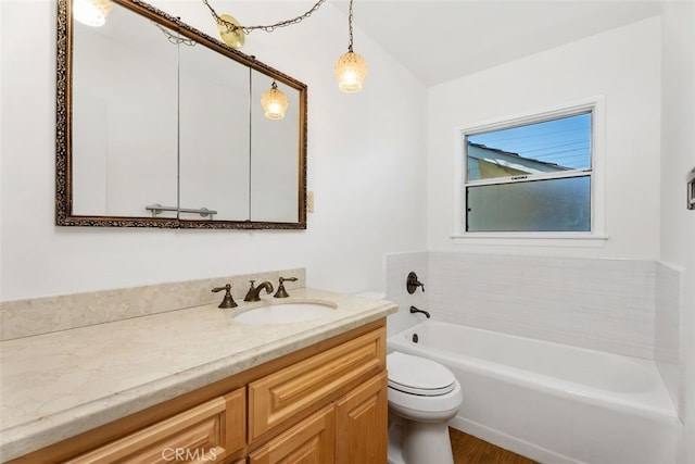 bathroom with toilet, vanity, a tub, and wood finished floors
