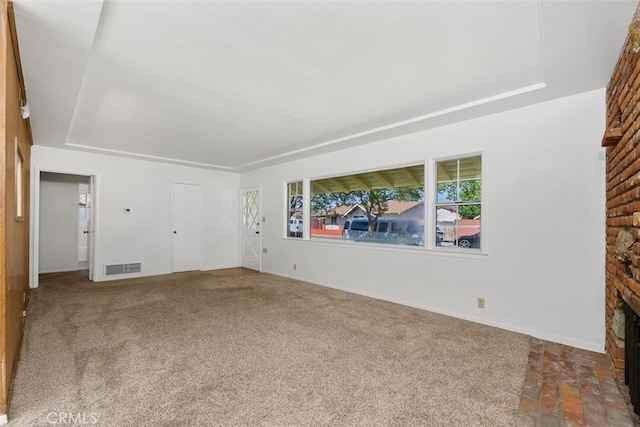 unfurnished living room with a brick fireplace, baseboards, and carpet floors