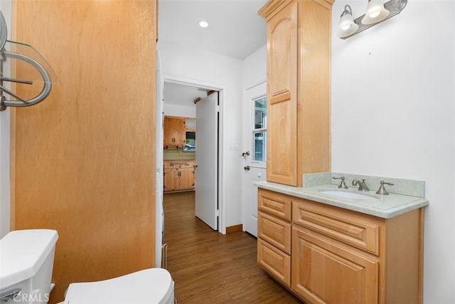 bathroom with toilet, wood finished floors, and vanity
