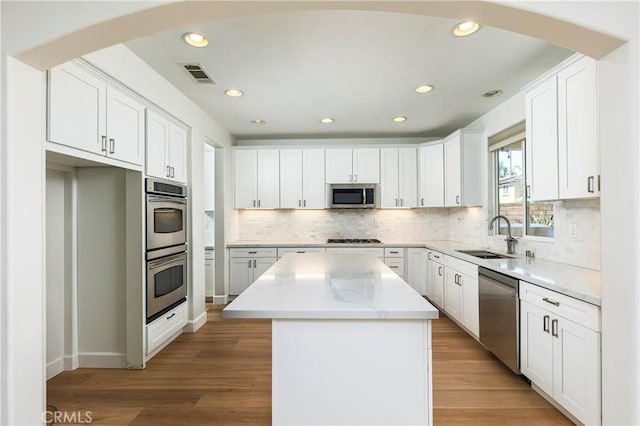 42442 Fiji Way, Temecula, CA 92592 - kitchen with a sink, stainless steel appliances, a kitchen island, recessed lighting, and white cabinetry