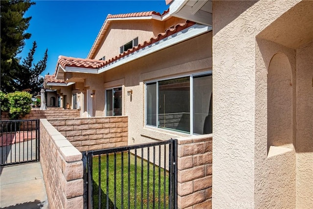 43473 30th St W Unit 4, Lancaster, CA 93536 - view of side of property featuring stucco siding, a tiled roof, and fence