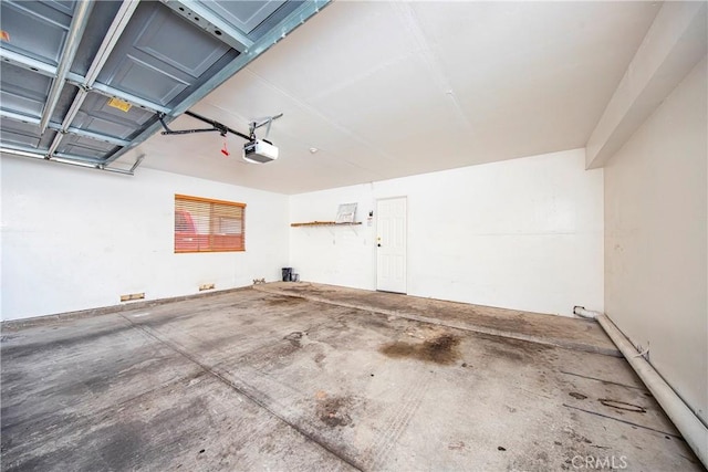 43473 30th St W Unit 4, Lancaster, CA 93536 - garage featuring a garage door opener and baseboard heating