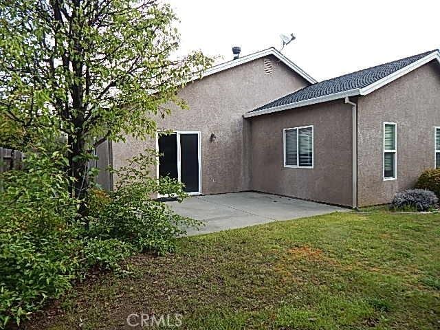 615 Vallecito Way, Red Bluff, CA 96080 - back of house with stucco siding, a patio area, and a lawn