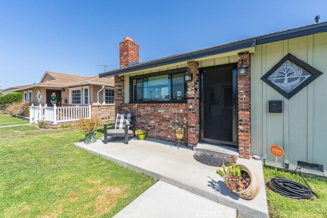 3717 W 182nd St, Torrance, CA 90504 - entrance to property with a chimney, a yard, covered porch, and brick siding