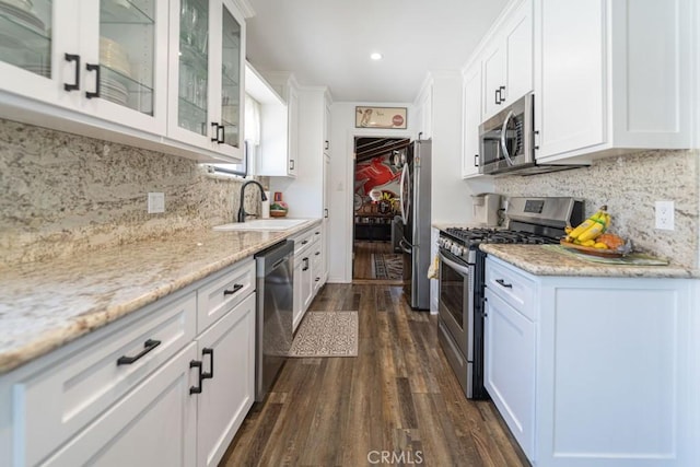3717 W 182nd St, Torrance, CA 90504 - kitchen featuring stainless steel appliances, dark wood-style floors, white cabinetry, decorative backsplash, and glass insert cabinets