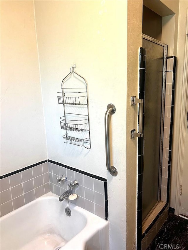 full bathroom featuring a shower stall and a garden tub