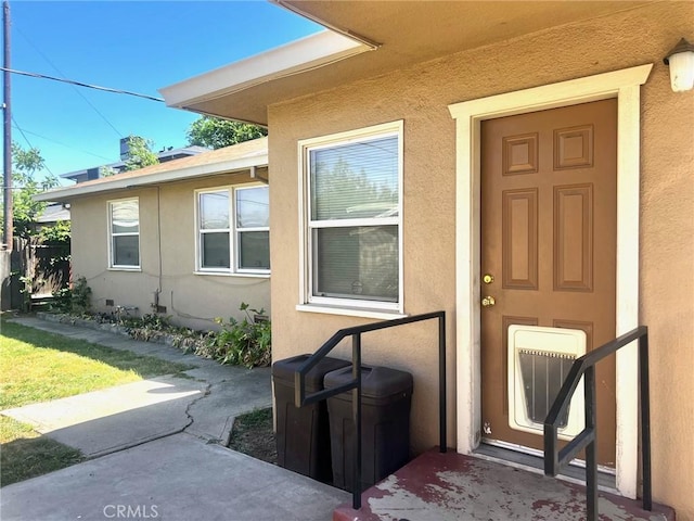 view of exterior entry with stucco siding