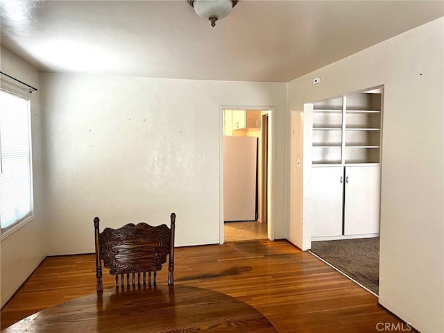 sitting room featuring wood finished floors and built in shelves