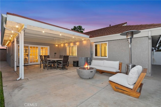 view of patio with cooling unit, outdoor dining area, and an outdoor living space with a fire pit