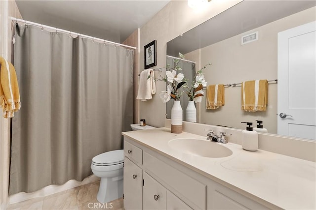 full bath featuring toilet, vanity, and curtained shower